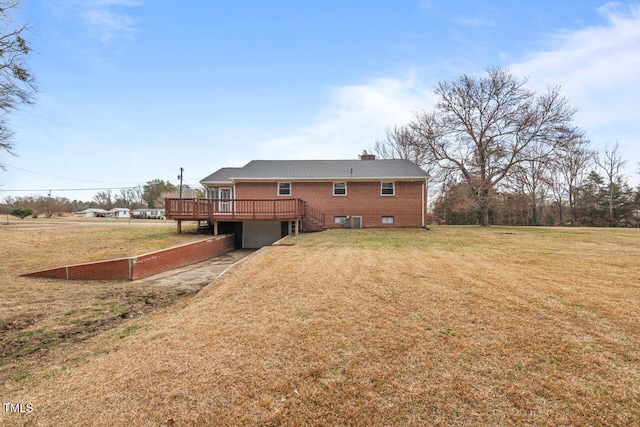 rear view of property featuring brick siding, a lawn, a chimney, and a wooden deck