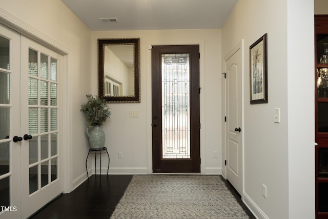 foyer entrance with visible vents, french doors, baseboards, and wood finished floors