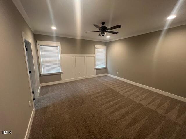 unfurnished bedroom featuring baseboards, dark carpet, ornamental molding, recessed lighting, and a decorative wall