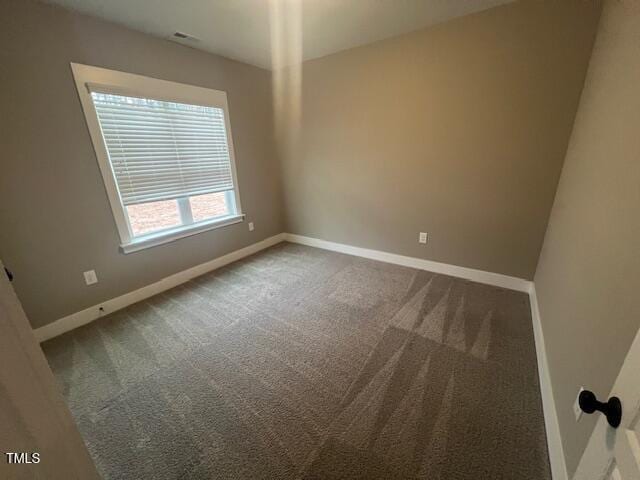 spare room with carpet and baseboards