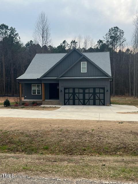 view of front facade featuring a garage, board and batten siding, and driveway