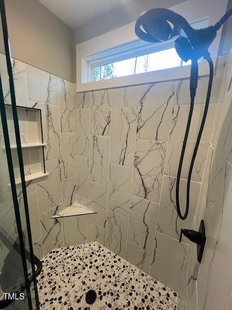 full bath with a marble finish shower