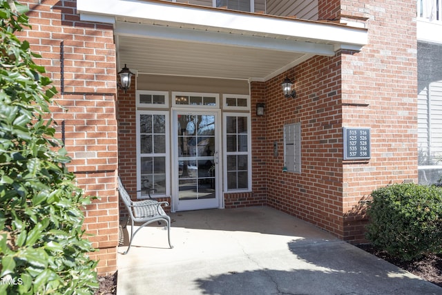 property entrance featuring brick siding