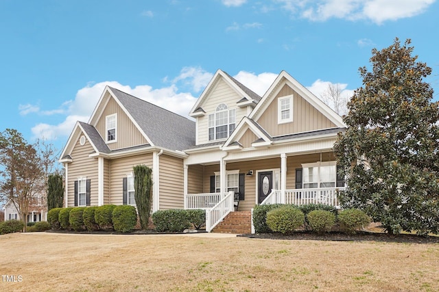 view of front of property featuring covered porch, board and batten siding, and a front yard