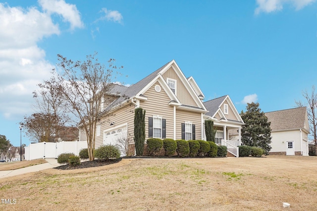 view of front of home with board and batten siding, a gate, fence, and a front lawn