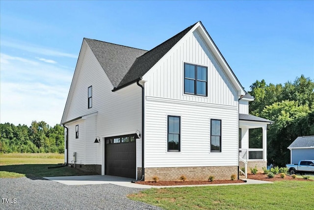 view of front of property with board and batten siding, a front yard, and a garage