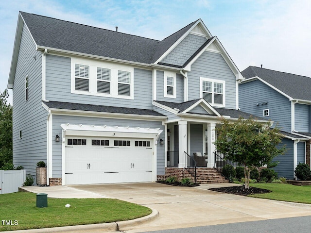 craftsman-style home featuring a garage, driveway, a shingled roof, and fence