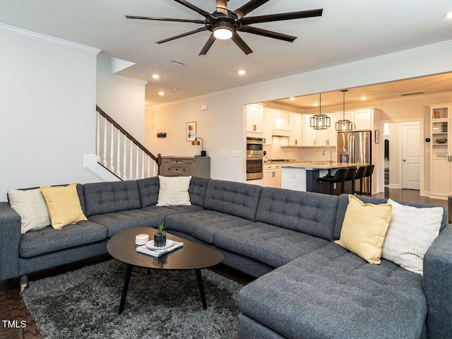 living area with stairs, visible vents, crown molding, and recessed lighting