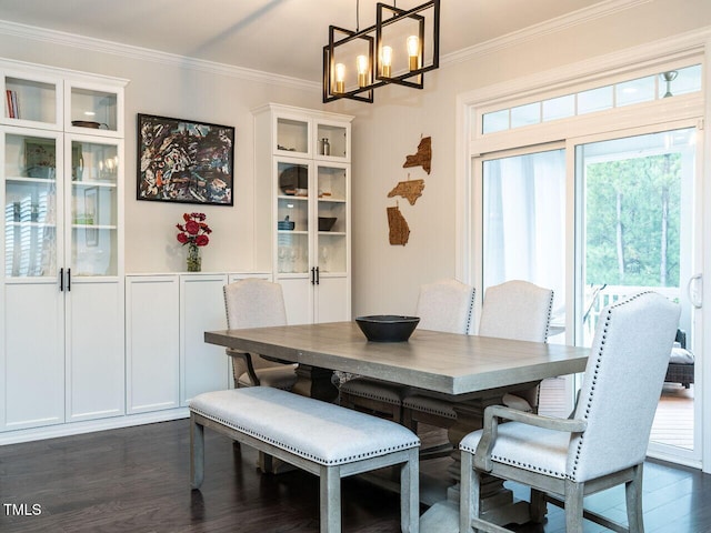 dining area featuring ornamental molding, dark wood-style flooring, and a notable chandelier