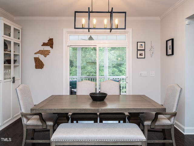 dining space featuring dark wood-style flooring, crown molding, baseboards, and an inviting chandelier