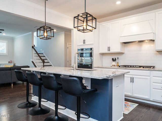 kitchen featuring decorative backsplash, appliances with stainless steel finishes, light stone counters, dark wood-type flooring, and premium range hood