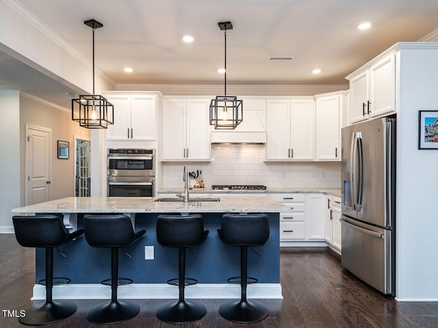 kitchen with visible vents, ornamental molding, stainless steel appliances, white cabinetry, and a sink