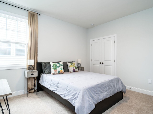 bedroom with carpet, a closet, and baseboards