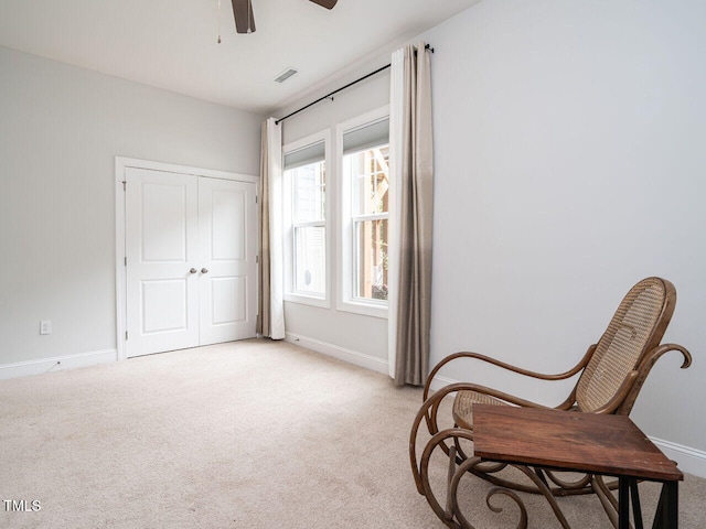 sitting room with baseboards, a ceiling fan, visible vents, and light colored carpet