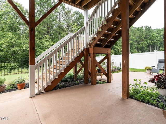 view of patio with fence and stairway