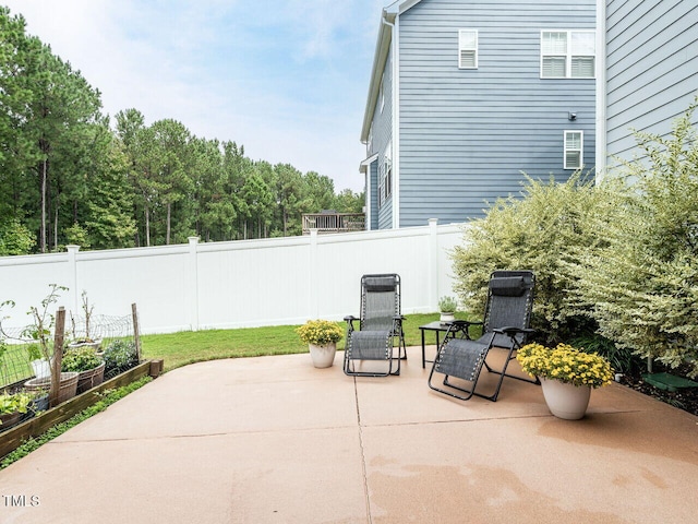 view of patio / terrace with a vegetable garden and fence