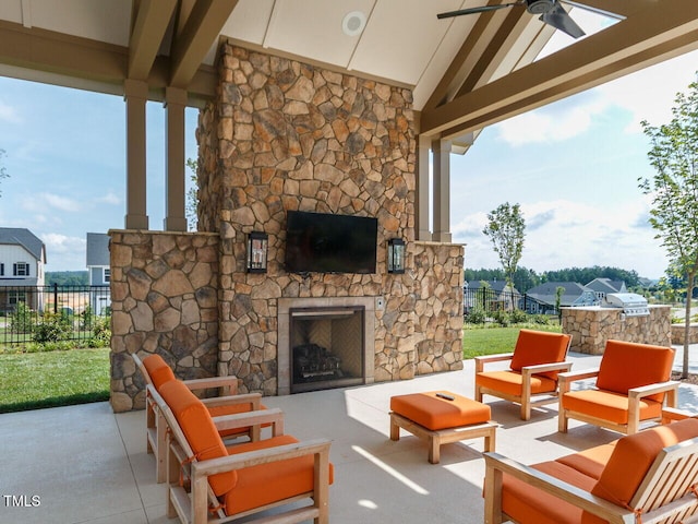 view of patio with fence, an outdoor living space with a fireplace, and ceiling fan