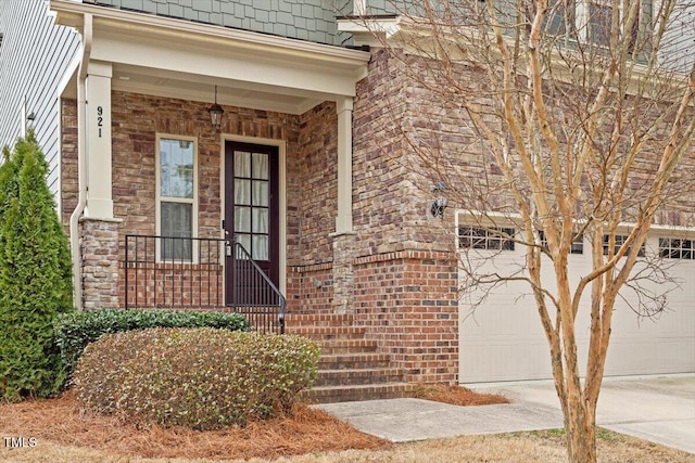 entrance to property with an attached garage, concrete driveway, and brick siding