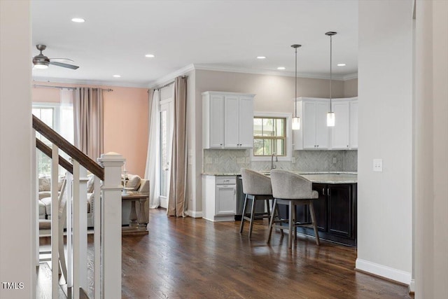 kitchen with white cabinetry, decorative backsplash, dark wood-style flooring, and ornamental molding