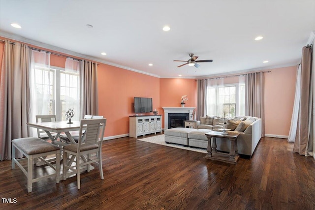 living area featuring baseboards, dark wood finished floors, crown molding, a fireplace, and recessed lighting