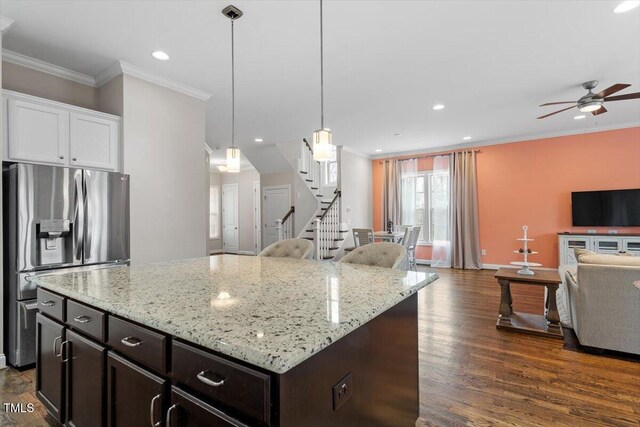 kitchen with dark wood-style floors, ornamental molding, open floor plan, white cabinetry, and stainless steel refrigerator with ice dispenser