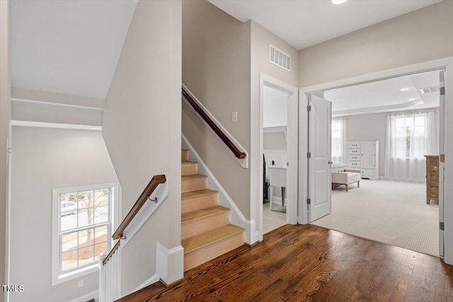 staircase with wood finished floors, visible vents, and recessed lighting