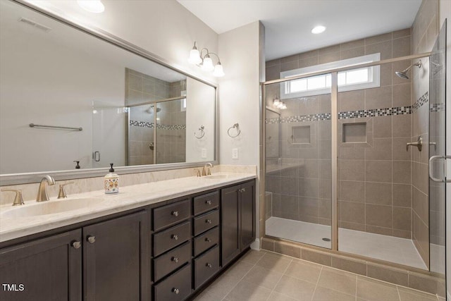 bathroom featuring a stall shower, visible vents, a sink, and double vanity