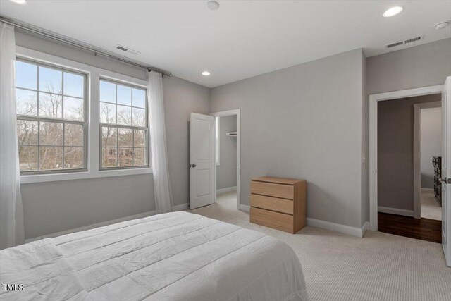 bedroom with baseboards, recessed lighting, visible vents, and light colored carpet