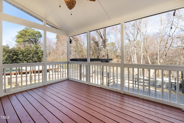 unfurnished sunroom with ceiling fan and vaulted ceiling