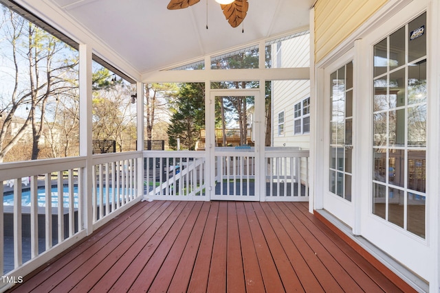 unfurnished sunroom with a ceiling fan and vaulted ceiling