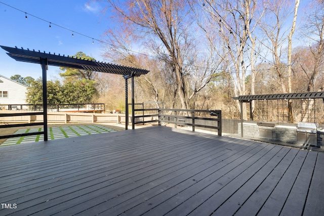 wooden terrace featuring exterior kitchen and a pergola