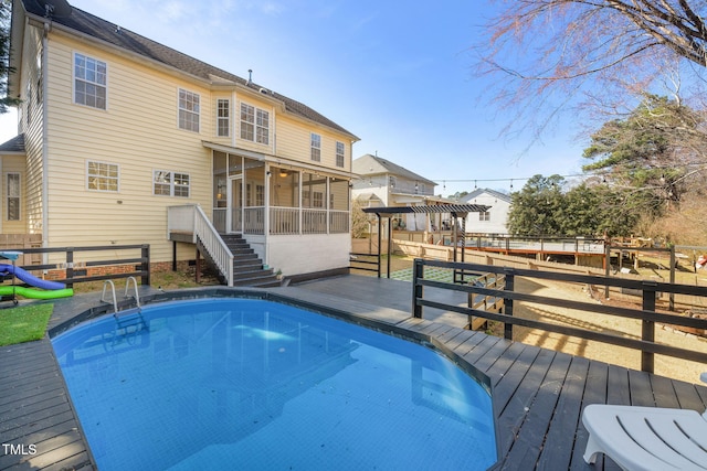 view of swimming pool with a sunroom and a deck