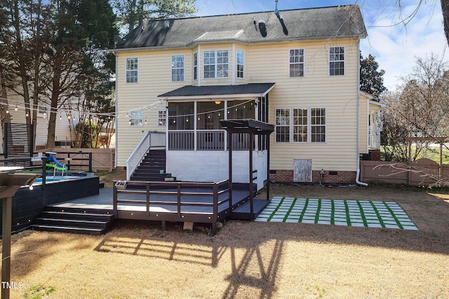 rear view of house featuring a deck, fence, a sunroom, a yard, and crawl space