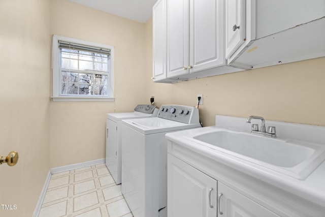 washroom featuring washer and clothes dryer, light floors, cabinet space, a sink, and baseboards