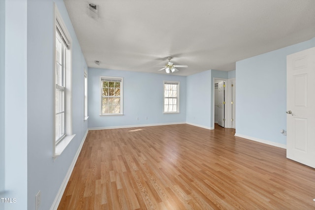 unfurnished room with ceiling fan, light wood-style flooring, and baseboards