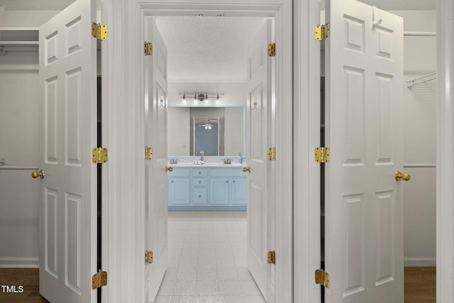 hallway with baseboards and a textured ceiling