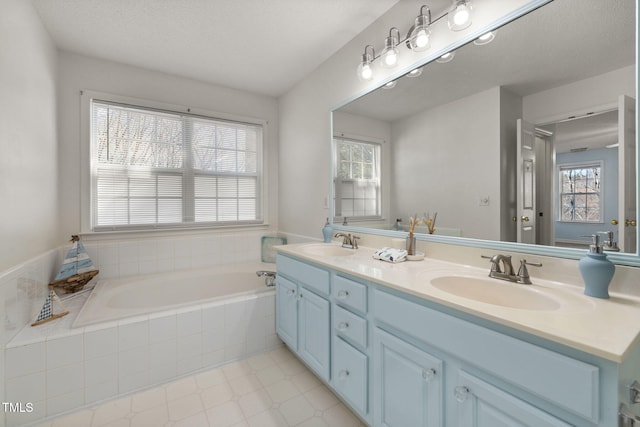 full bathroom featuring a wealth of natural light, a garden tub, and a sink