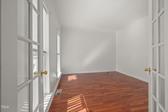 spare room featuring french doors, visible vents, crown molding, and wood finished floors