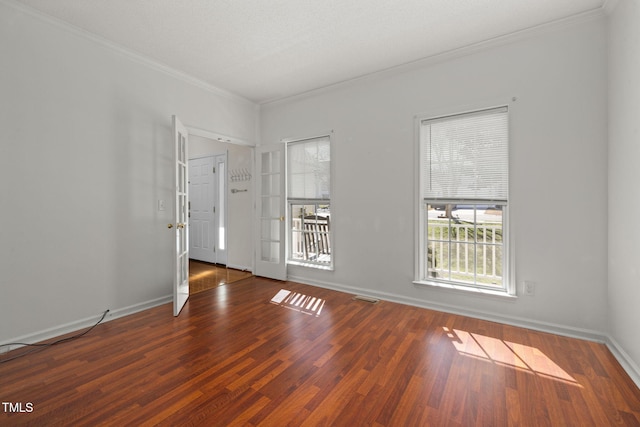 unfurnished room with ornamental molding, wood finished floors, visible vents, and baseboards