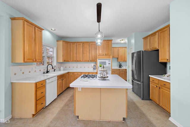 kitchen featuring a center island, white appliances, light countertops, and a sink