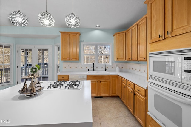 kitchen featuring white appliances, light countertops, a sink, and light tile patterned flooring