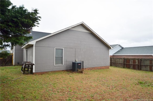 view of property exterior with a yard, cooling unit, and fence