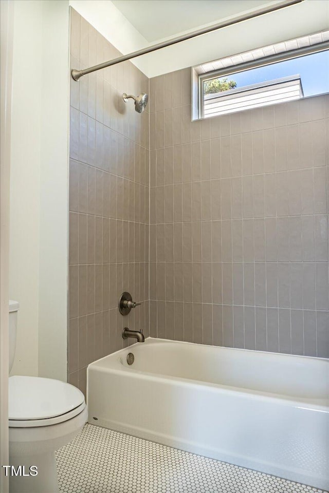 bathroom featuring toilet,  shower combination, and tile patterned floors