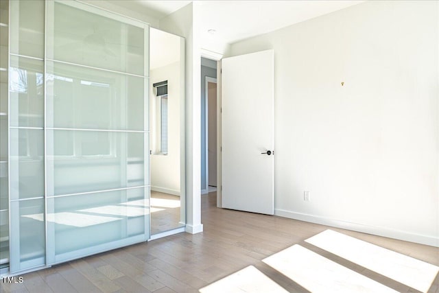 unfurnished bedroom featuring wood finished floors and baseboards