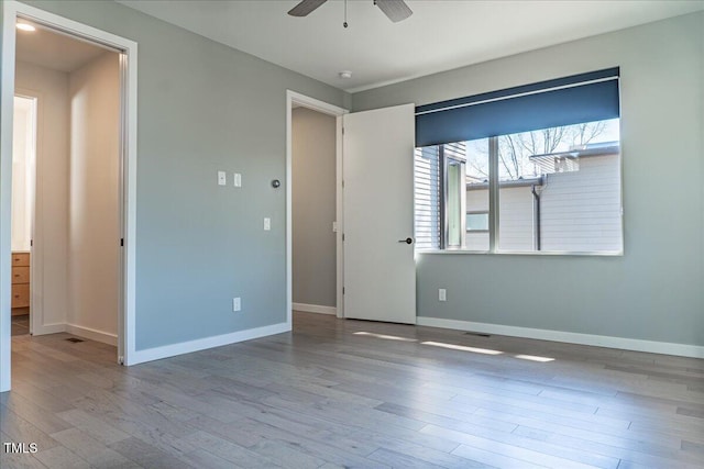 unfurnished bedroom with a ceiling fan, baseboards, and wood finished floors