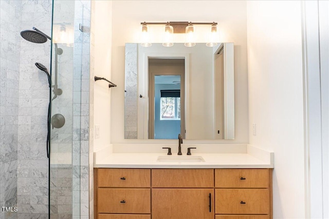 full bathroom featuring a tile shower and vanity