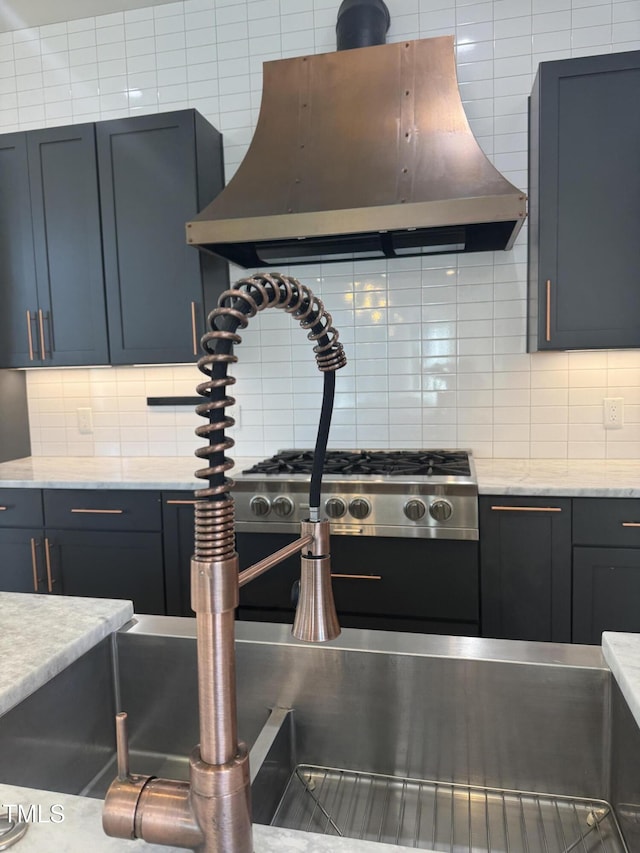 kitchen with decorative backsplash, island range hood, and light stone countertops