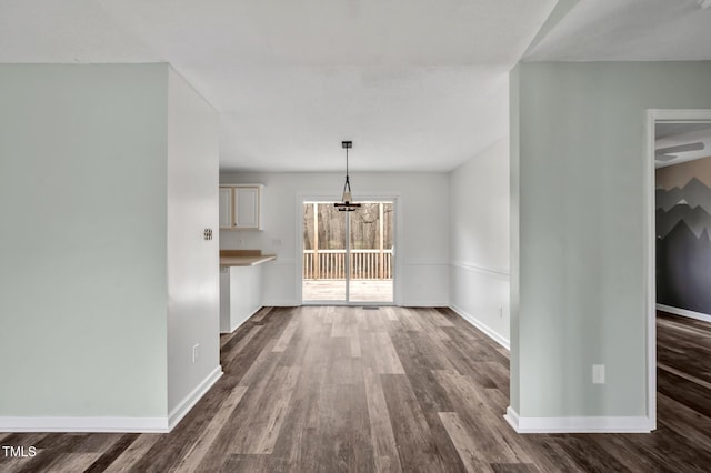 interior space featuring dark wood-type flooring and baseboards