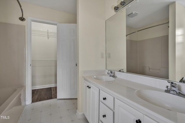 bathroom with double vanity, a sink, visible vents, and tile patterned floors