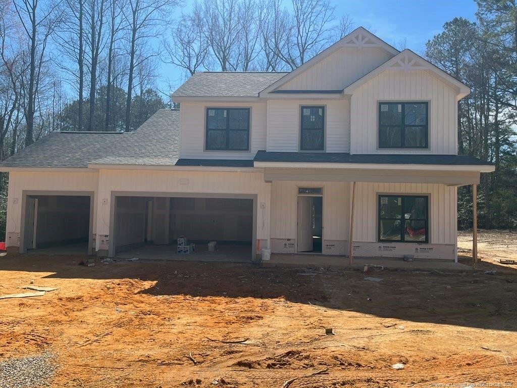 view of front of home with board and batten siding, a porch, roof with shingles, and dirt driveway